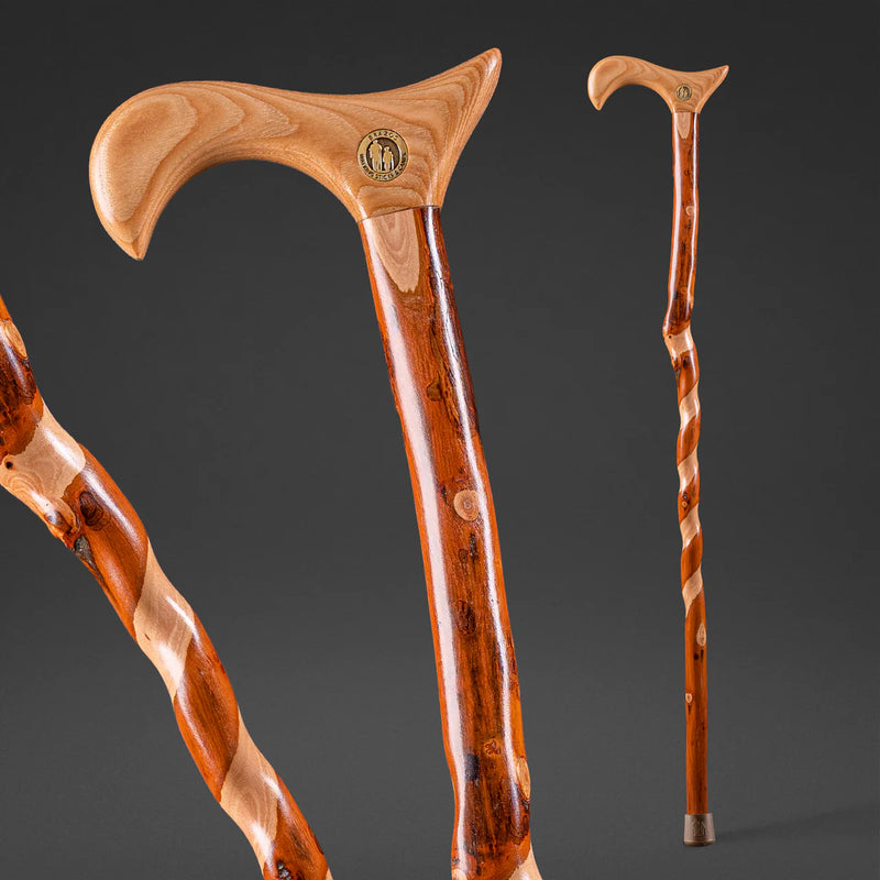 Three wooden walking sticks with decorative handles on a dark background