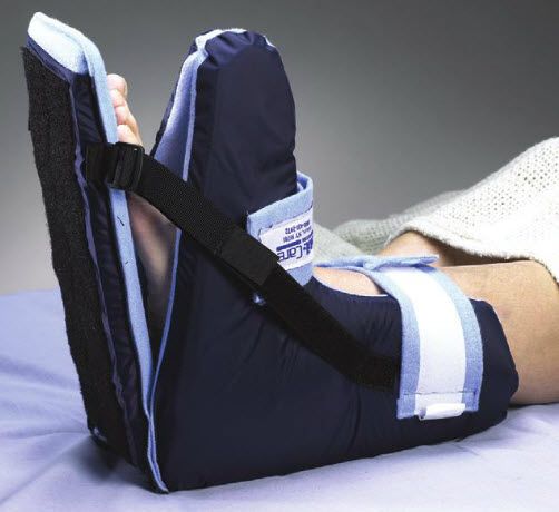 Person wearing a foot brace with straps on a gray background