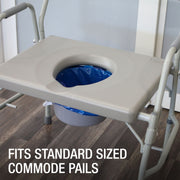 A beige plastic seat tray with a circular opening, shown mounted on a white metal commode frame over a gray bucket with a blue liner. The image is set on a dark wood floor with a text overlay at the bottom reading 'FITS STANDARD SIZED COMMODE PAILS'.