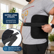 A man wearing a black electric waist trainer belt with a power cord, shown in a bright living room. The image includes text overlays explaining the product features: 'EXTRA LONG STRAPS' and 'ONE SIZE FITS MOST'.