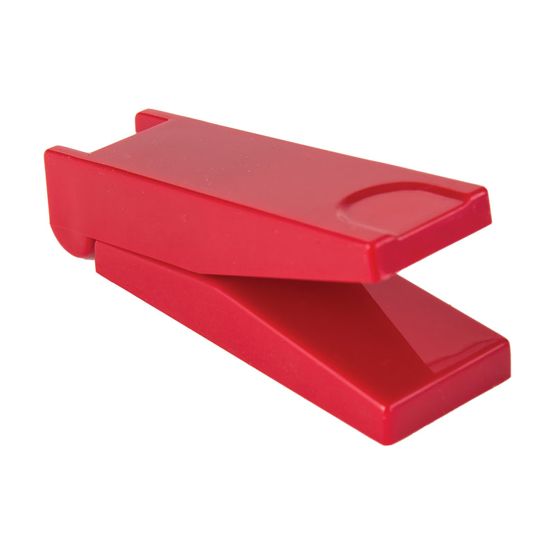 A bright red pill cutter shown open on a plain white background.