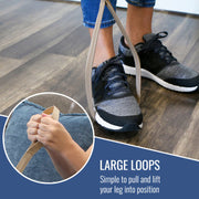 A person wearing black and gray sneakers stands on a wood floor while pulling a beige fabric loop attached to their leg. A circular inset shows a close-up of the loop being pulled by hands.