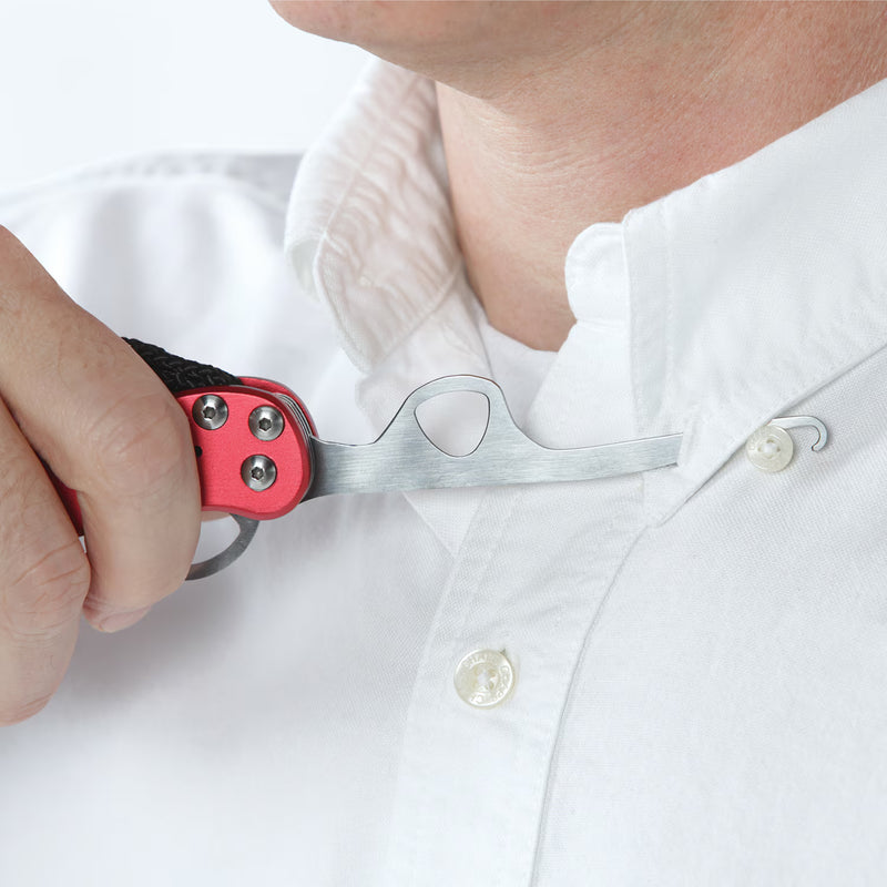 A close-up of a person wearing a white button-down shirt, using a red and silver neck lanyard release tool to loosen a button.