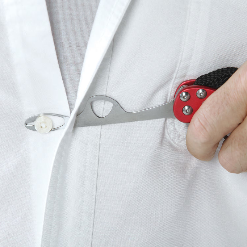 A close-up of a hand holding a red and black pocket tool against a white button-down shirt, demonstrating its use on a button.