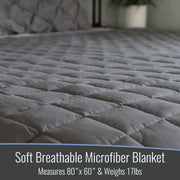 Gray soft breathable microfiber blanket on a bed with text about dimensions and weight.