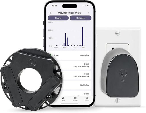 A smart home motion detector set shown on a white background, including a black circular sensor device, a smartphone displaying a motion-activity app interface, and a gray-and-black plug-in device mounted on a white wall outlet.