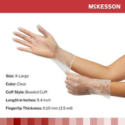 Clear vinyl gloves being worn with McKesson branding and product details.