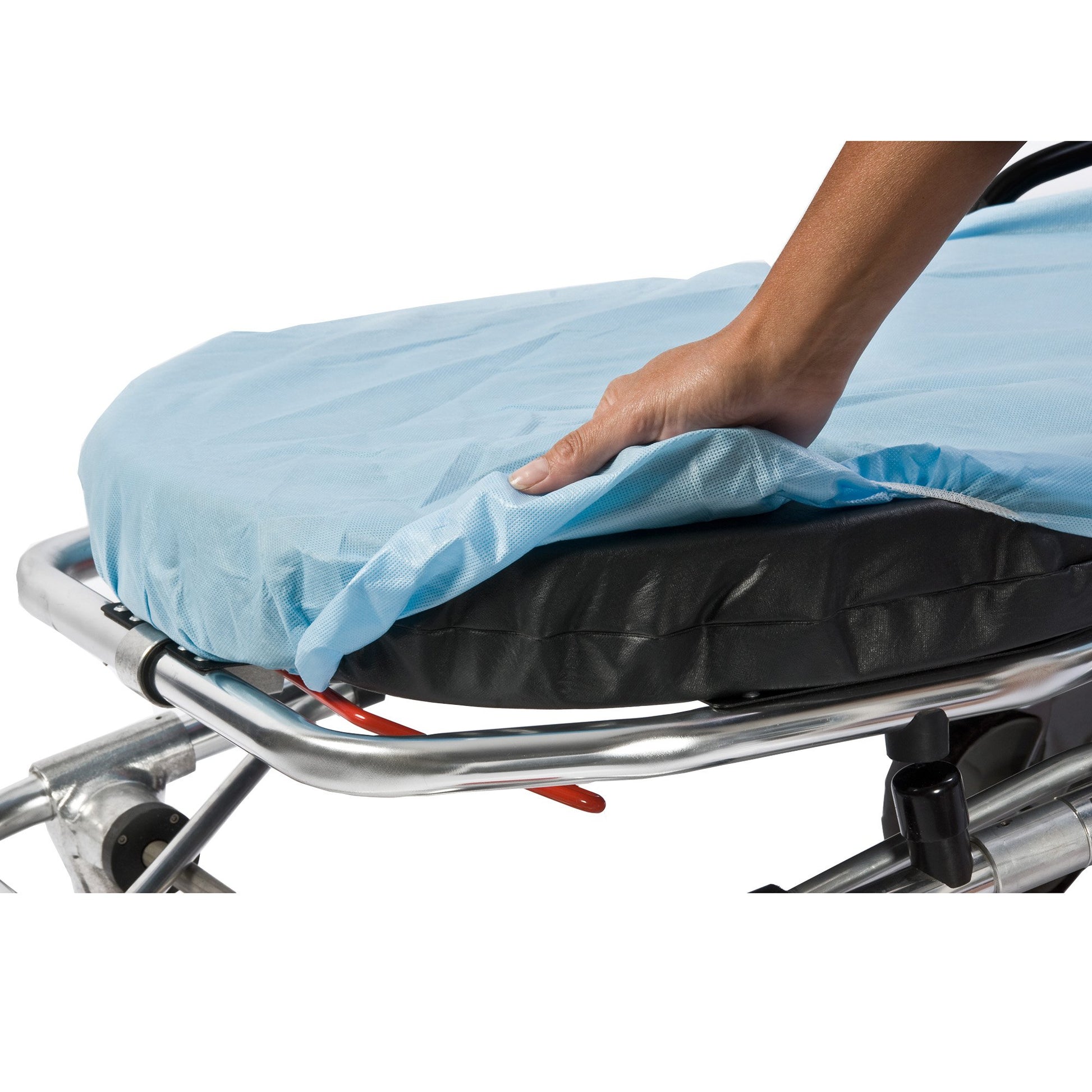 Hand placing a blue sheet over a medical stretcher