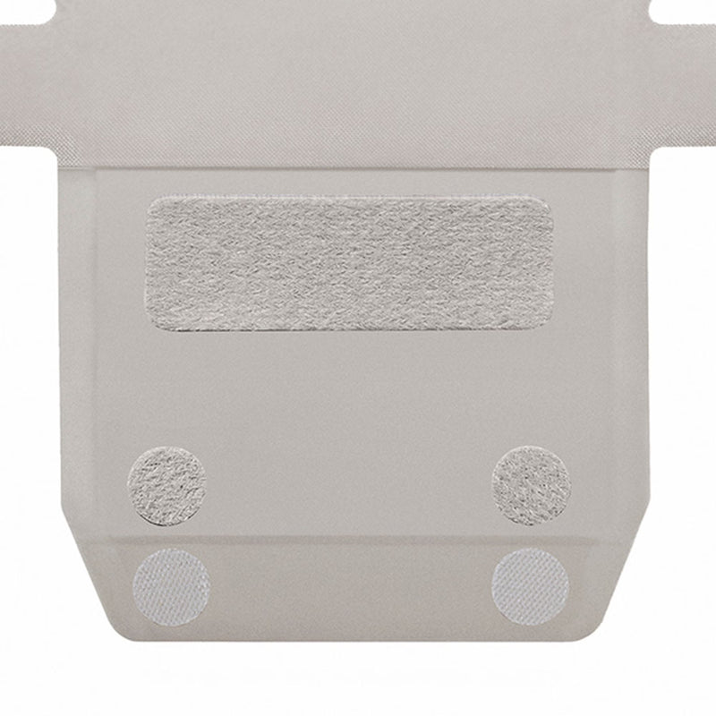 A close-up of a light gray textured panel with a rectangular velcro patch and two circular textured adhesive dots on a white background.
