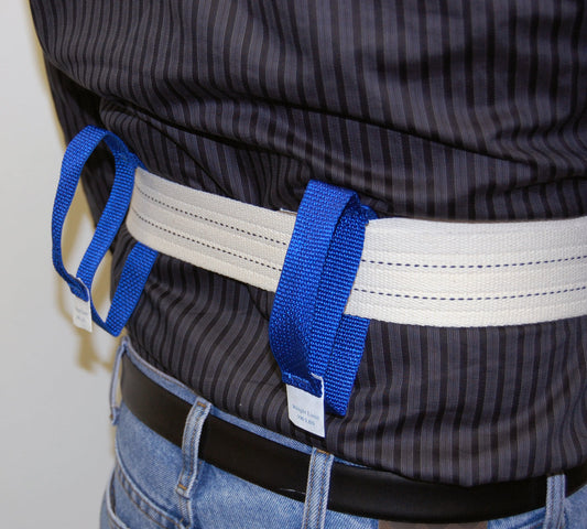 Person wearing a harness with blue straps and a white label, against a neutral background.