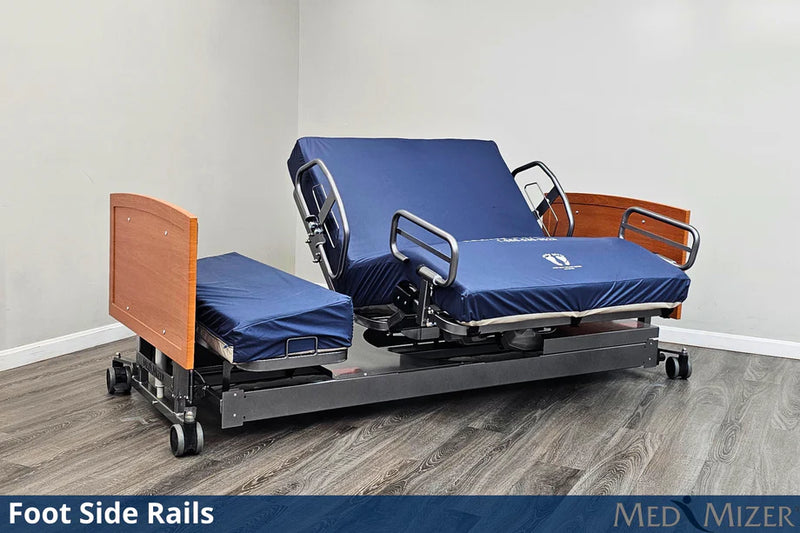 Electric hospital bed with foot side rails on a wooden floor, featuring Med Mizer branding.