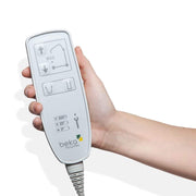 A hand holding a white Beko hospital remote control with buttons and a coiled cord, shown against a plain white background.