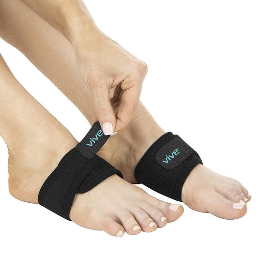 Person wearing black ankle support straps with 'Vive' branding on a white background