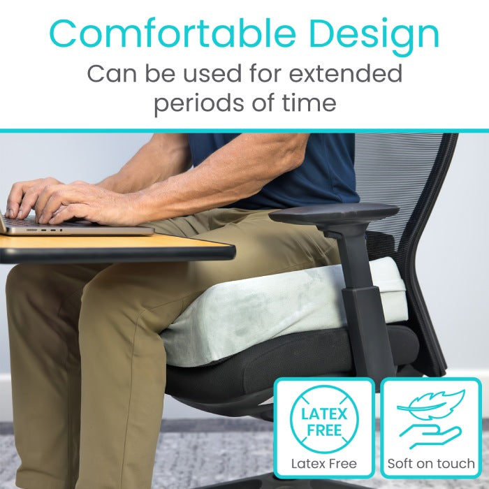 Person using a laptop with a chair cushion labeled 'Comfortable Design' and 'Latex Free, Soft on Touch'.