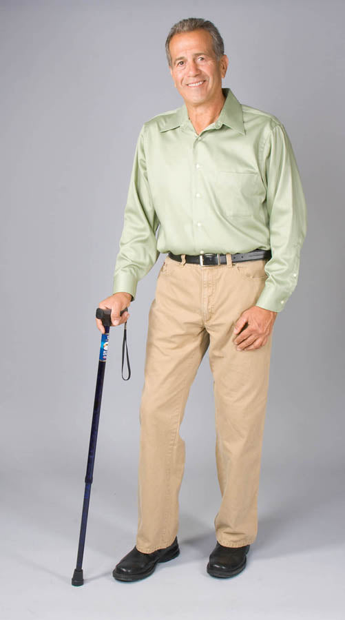 Man wearing a light green shirt and beige pants, holding a walking cane on a gray background
