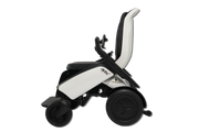 A side profile view of a modern power wheelchair with a white and black seat, black wheels, and a black headrest support, isolated on a white background.