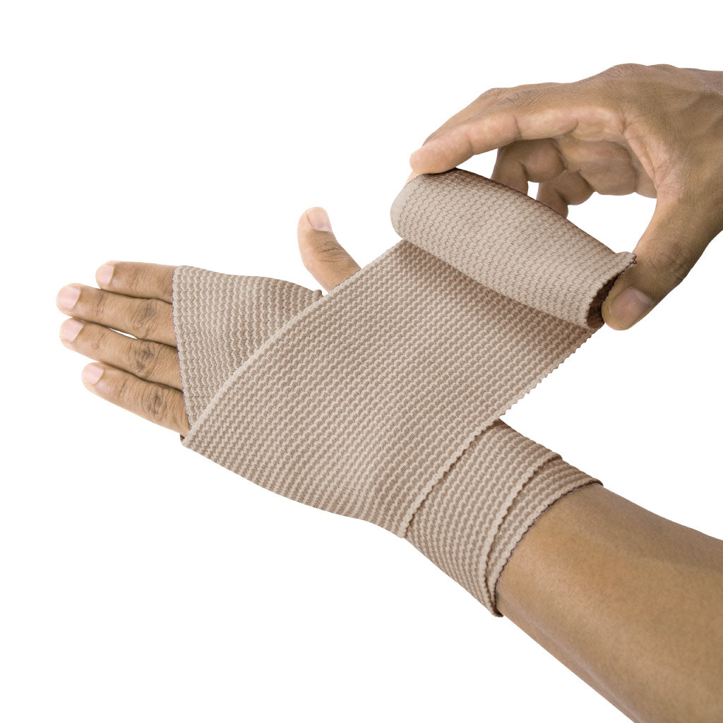 Hand being wrapped with beige elastic bandage on a white background