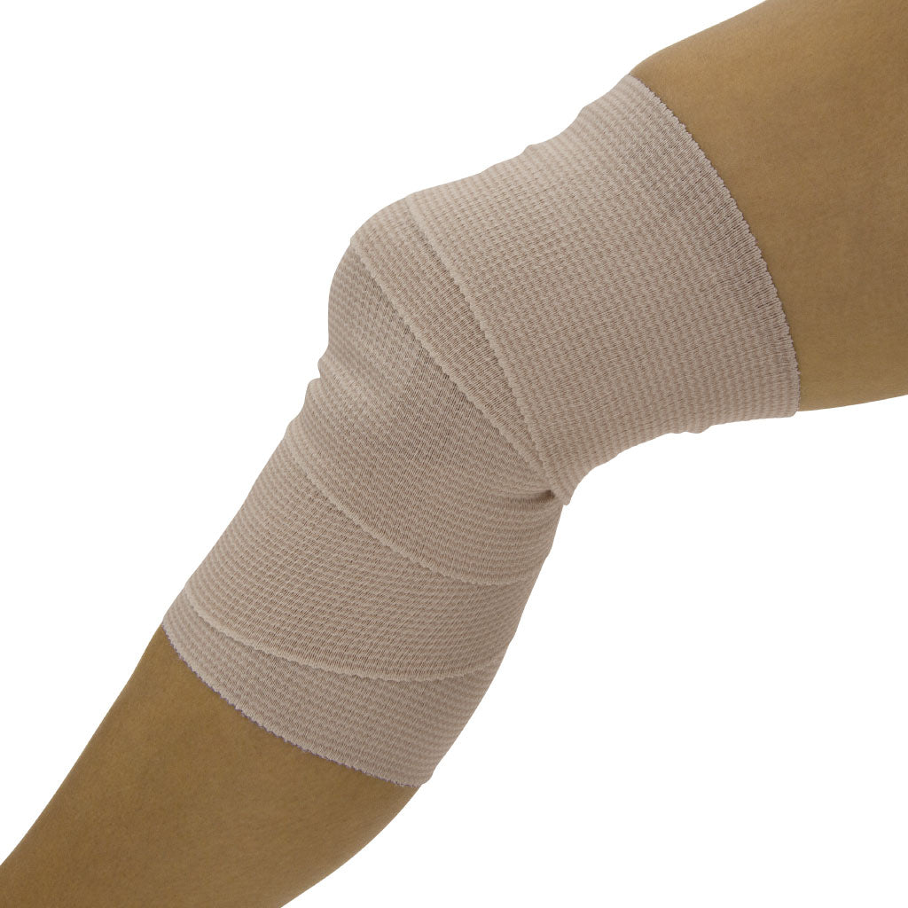 Beige elastic bandage on a person's arm against a white background