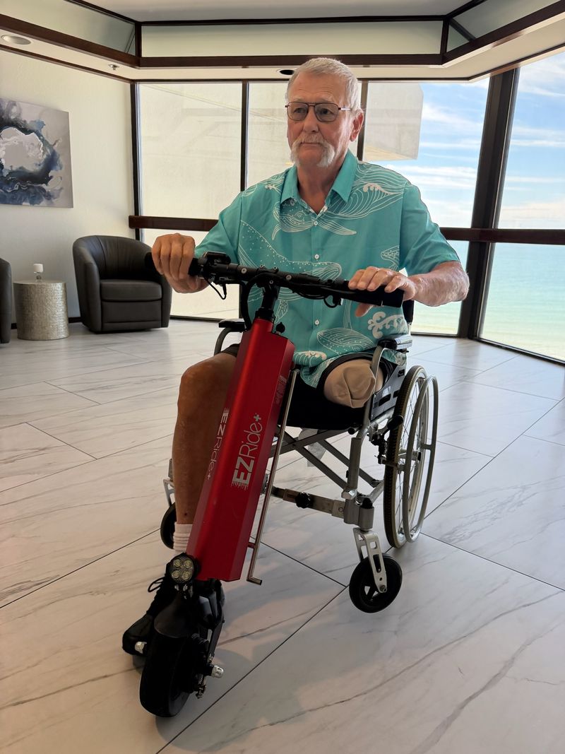 Man using a wheelchair with an attached scooter in a modern indoor setting
