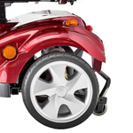 Close-up of a red mobility scooter wheel with visible brand logo.