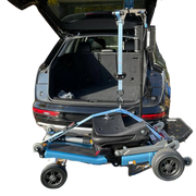Blue and black vehicle ramp attached to a car with open trunk on a white background