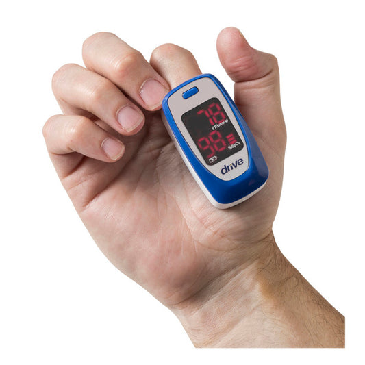 Hand holding a blue and white pulse oximeter on a white background