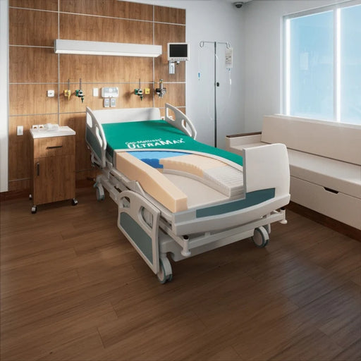 Hospital bed with 'Ultramax' branding in a room with wooden floor and window.