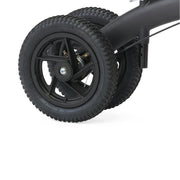 Close-up of a black wheel with tread pattern on a white background