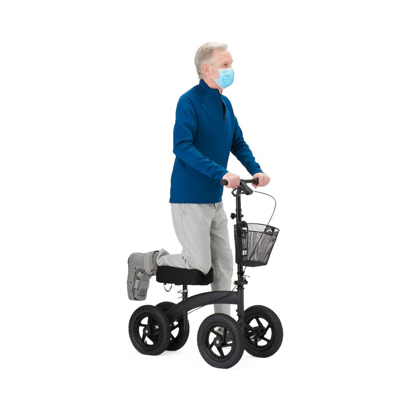 Person using a knee walker with a basket on a white background