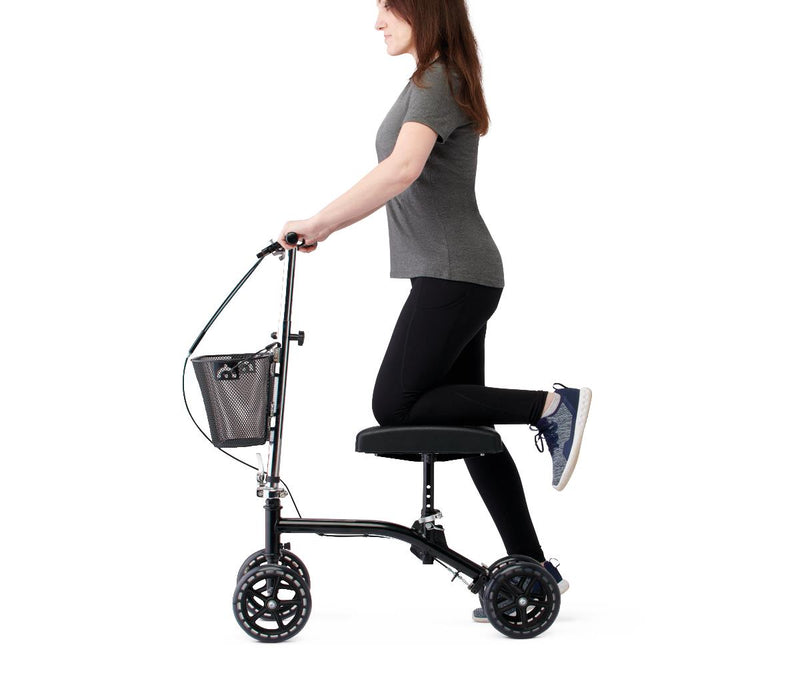 Person using a knee walker on a white background