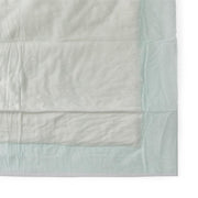 Light blue quilt with a subtle pattern on a white background
