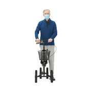 Man wearing a blue face mask and blue sweater using a three-wheeled mobility scooter on a white background