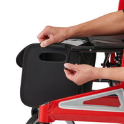 Person adjusting a black tray on a red and gray chair.