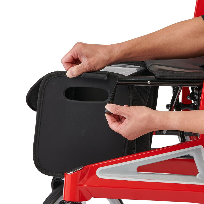 Person adjusting a black tray on a red and gray chair.
