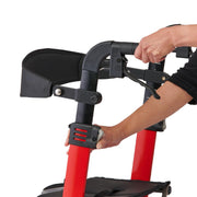 Person using a red and black walker with a close-up of the handle and legs.