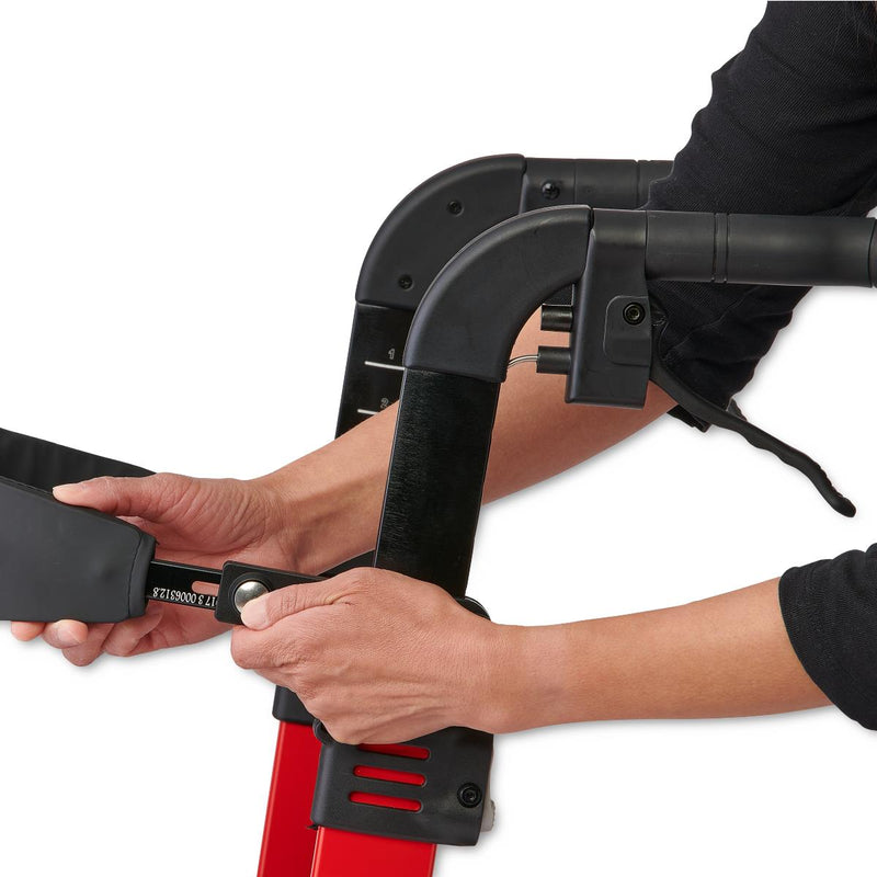 Person adjusting a red and black scooter with a white background