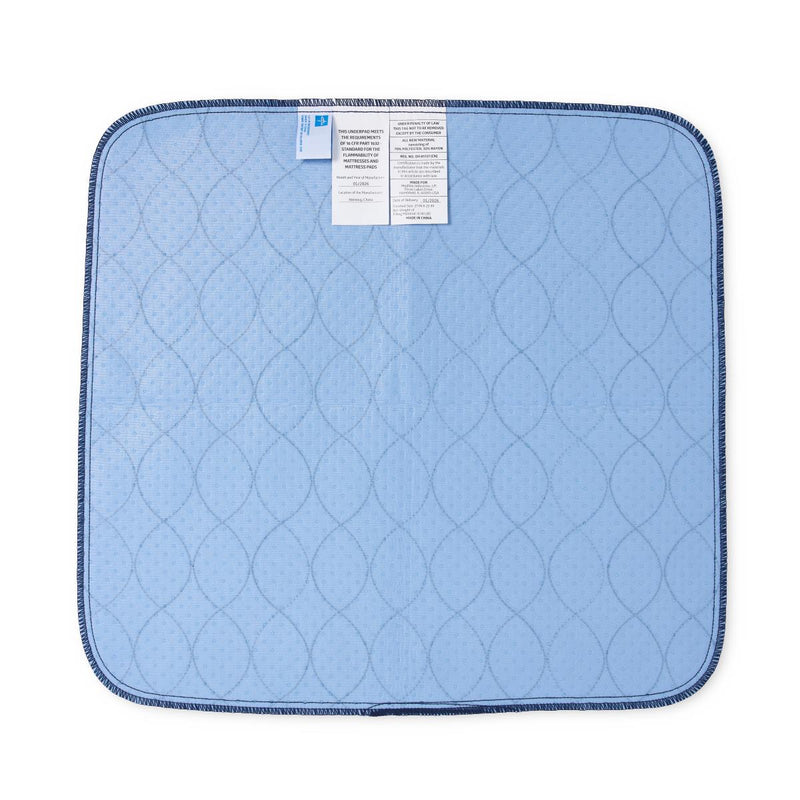 A light blue quilted underpad with a dark blue stitched border and two white product tags attached near the top edge, shown on a plain white background.