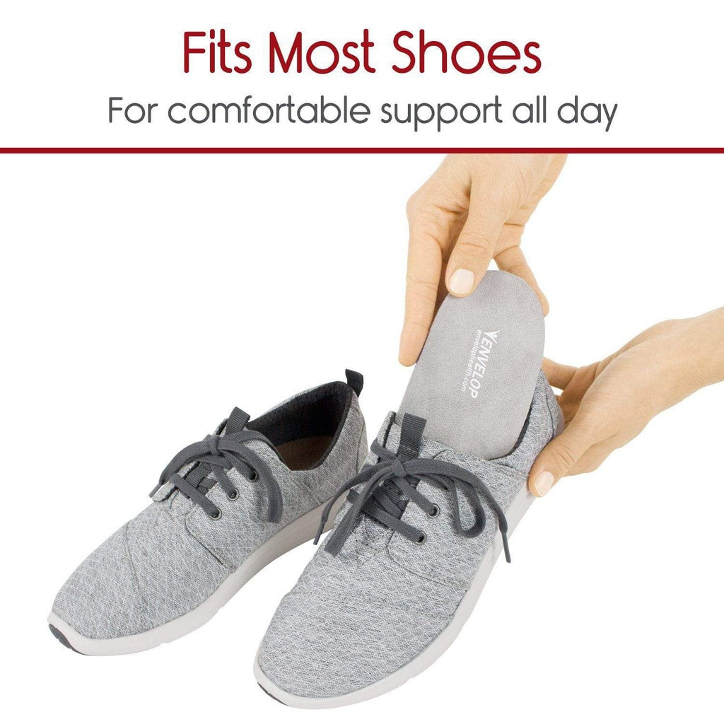 Gray sneakers with a shoe insert being inserted, on a white background.