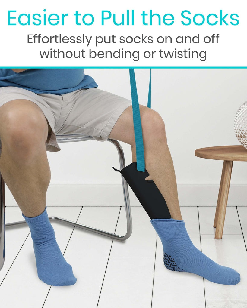 Person wearing blue socks with a sock aid, sitting on a chair.