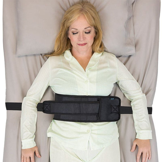 Woman wearing a black waist support belt in a neutral setting