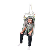 A man sitting in a suspended mesh chair with a white frame and green trim, shown against a plain white background.