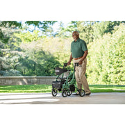 Man pushing a green and black stroller in a park setting