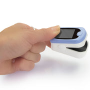 Finger pulse oximeter being used on a finger with a white background