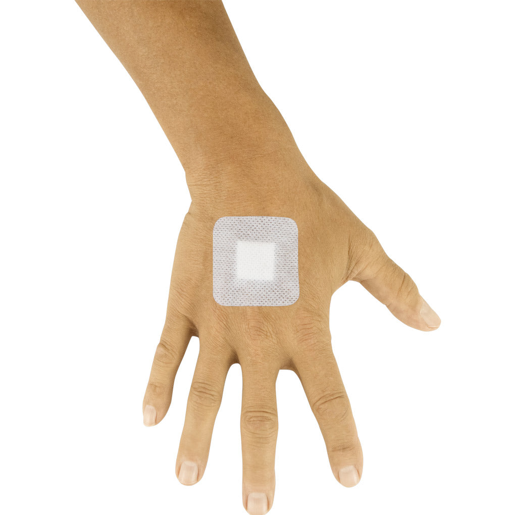 Square adhesive patch on a person's hand against a white background