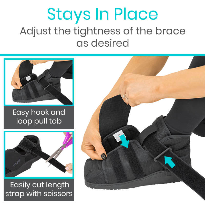 Black foot brace with adjustable straps being demonstrated on a person's foot.