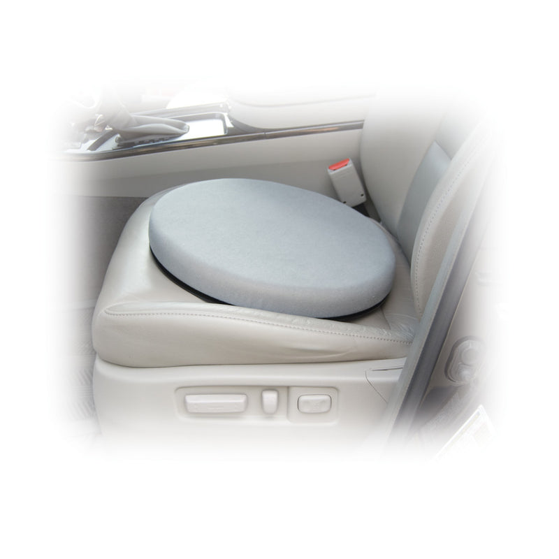 A round gray car seat cushion placed on a light beige car seat, shown inside a vehicle with a blurred white vignette around the edges.