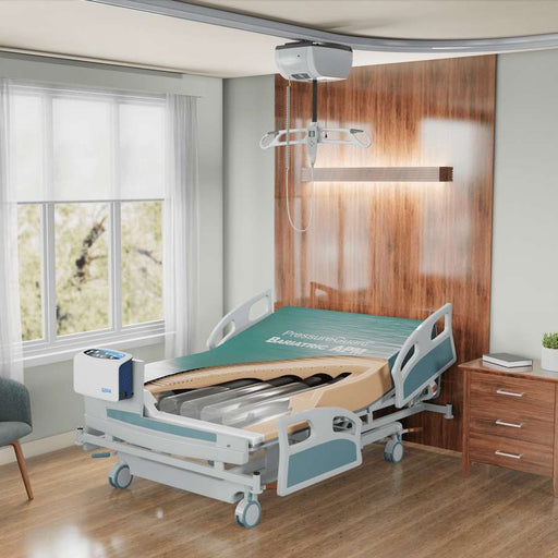 A hospital-style adjustable patient bed with side rails, a mattress, and an overhead medical light bar in a staged bedroom-like room with wood paneling, a window, and a bedside cabinet.