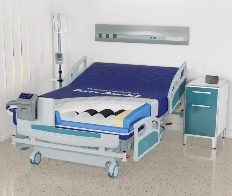 An electric hospital bed with a blue mattress and white/teal frame, shown in a clean clinical room with a side table, IV pole, and wall-mounted medical panel.