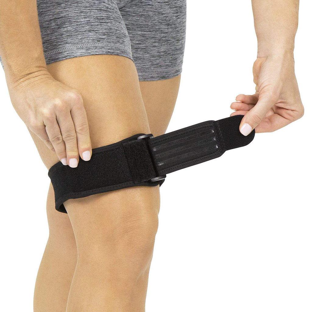 Person wearing a black compression wrap on their leg against a white background