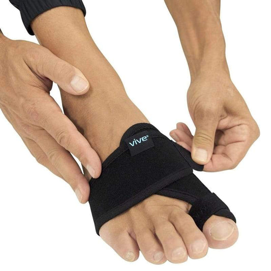 Person wearing a black Vive foot brace on a white background